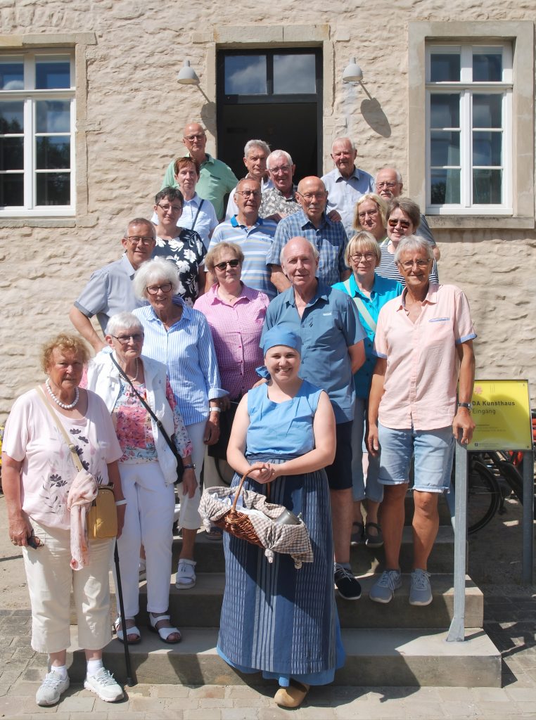 Die Teilnehmer der Brochterbeceker Gruppe stehen auf einer Treppe. Vorne steht Miktrinken, die Magd aus dem Kloster Gravenhorst.